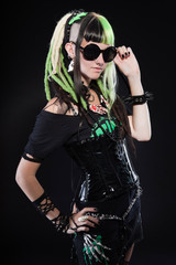Cyber punk girl with green blond hair and red eyes against black