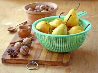 Pears,  walnuts, cinnamon and ginger on a wooden table