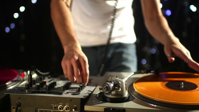 studio shoot of a cool male dj behind the turntables