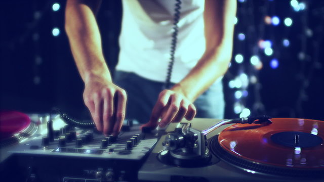 studio shoot of a cool male dj behind the turntables