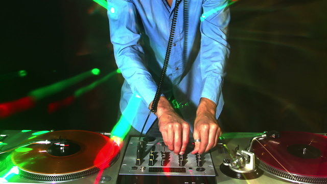 studio shoot of a cool male dj behind the turntables