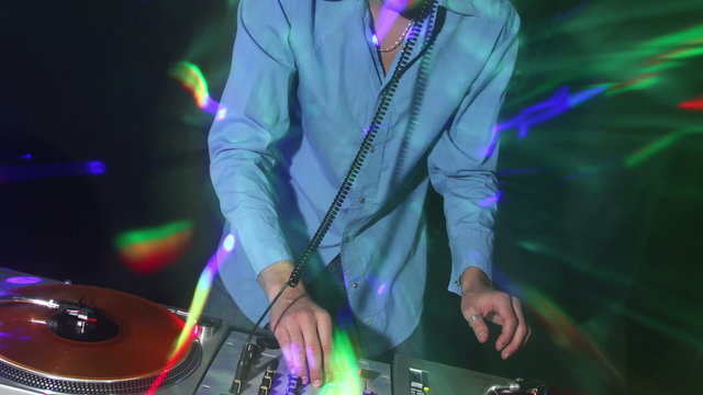 studio shoot of a cool male dj behind the turntables