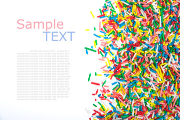 Border made of little colorful candy isolated on white