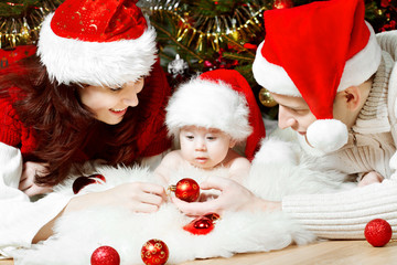 Fototapeta na wymiar Rodzinne Święta z dzieckiem w czerwonych czapkach daje prezenty