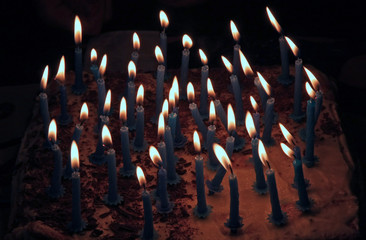lighted candles on a cake with cream for the birthday party