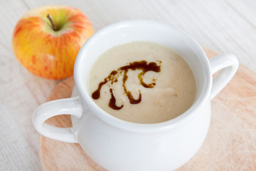 Celery apple vegetable cream soup in white bowl
