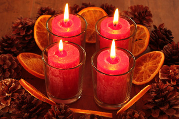 Orangenscheiben, Kiefernzapfen und Kerzen