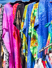 Clothing and fabrics in street market stall