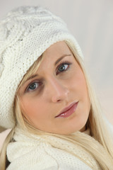 Young woman in a white knitted hat and scarf