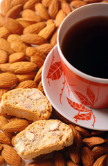 Coffee cup with biscotti on almond background
