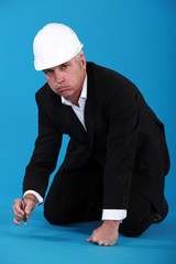 Bored architect writing on the floor