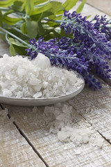 Obraz na płótnie Canvas Sea salt in bowl with lavender on white wooden background