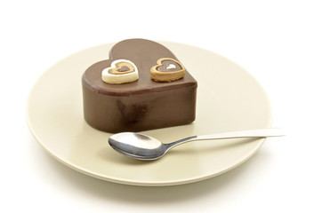 Chocolate cake with heart shape on a plate with cutlery