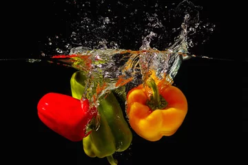 Rolgordijnen Rode, groene en gele paprika die in het water valt © Boris Bulychev