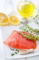 Raw salmon on the white plate with thyme and salt