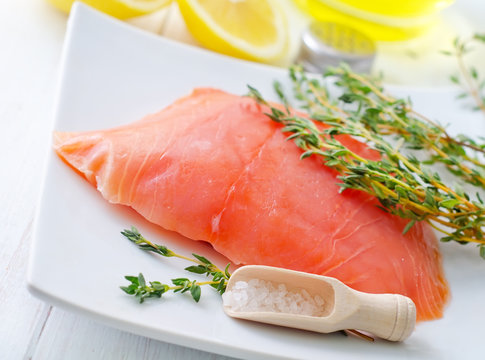 Raw salmon on the white plate with thyme and salt