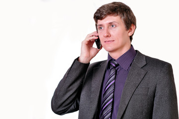Young businessman in violet tie speaks by phone