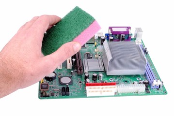man hand with a sponge cleans a mother board isolated