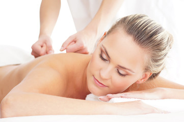 Fototapeta na wymiar A young woman laying on a spa massage procedure