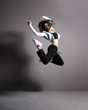 A young and fit brunette woman dancing in sporty clothes