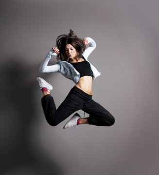 A young and fit brunette woman dancing in sporty clothes
