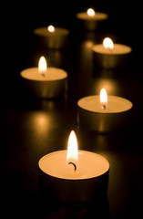 Fototapeta na wymiar Small candles in dark. Holiday/romance/religion concept