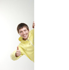 A young teenage boy holding a large blank white banner