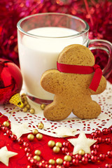 Gingerbread man with a cup of milk and christmas ornaments