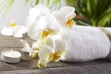Obraz na płótnie Canvas Orchids and towel on wooden boards spa concept