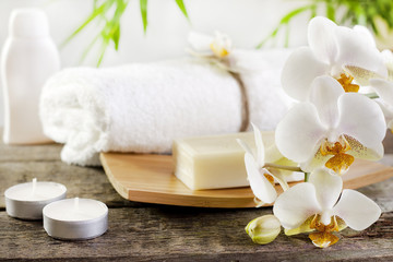 Orchids spa soap and towel concept on wooden boards