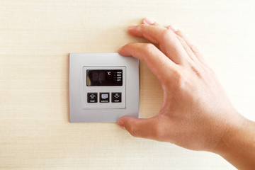 Hand with finger on air conditioner switch control