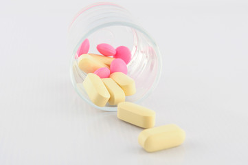Yellow and pink tablet in dosage glass