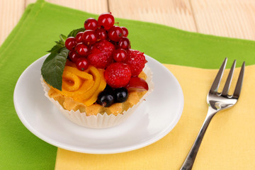 Dulcet cake with fruit and berries on wooden table