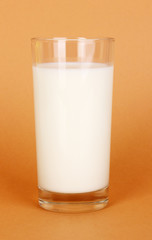 Glass of fresh new milk on brown background