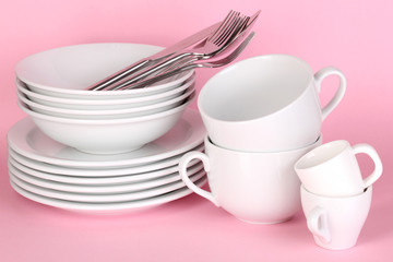 Clean white dishes on pink background