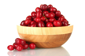 fresh cornel berries in wooden bowl isolated on white