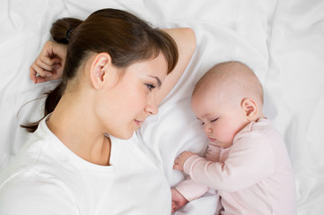 Young mother looking at her sleeping baby