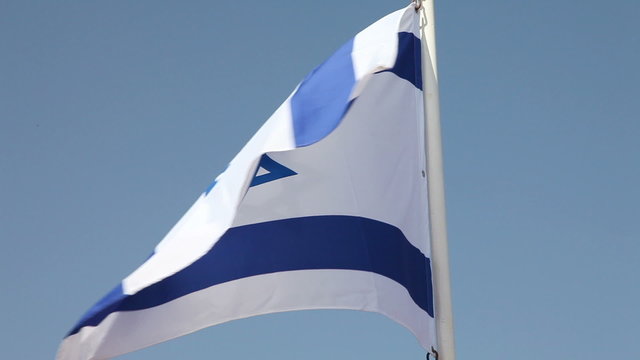 Israel flag waving in wind against clear blue sky