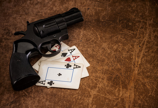 black revolver and old playing cards