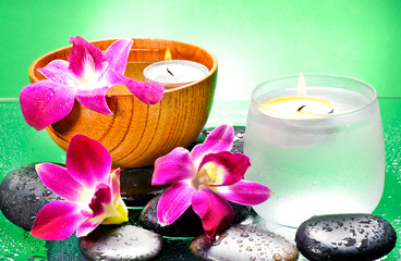 Image of spa therapy, flowers in water, on a bamboo mat.