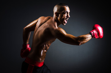 Boxer with red gloves in dark room