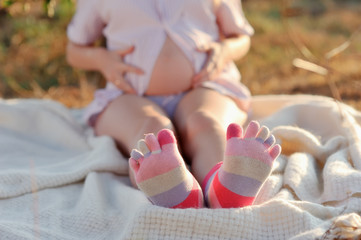 outdoors sitting pregnant woman with colored socks on feet