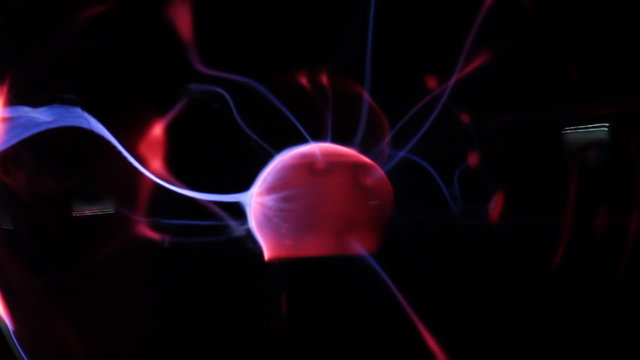 View of plasma ball with moving energy rays  on black background