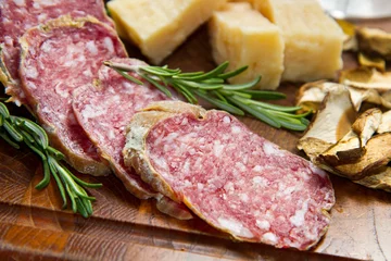   parmesan cheese and salami on wooden board © Lsantilli