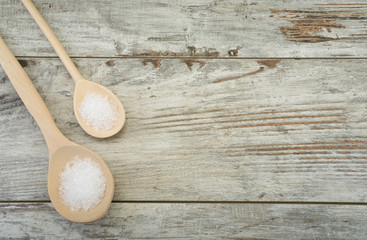 Fototapeta na wymiar Dwie łyżki soli morskiej na stole z miejsca na tekst