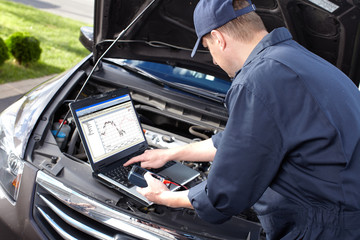 Car mechanic working in auto repair service.