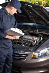 Car mechanic working in auto repair service.