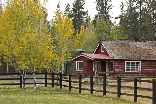 Vintage wooden red ranch house with autumn foliage