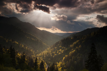 Sunlight from a setting sun breaking through breaking storm clouds over Morton Overlook in the Smoky Mountains