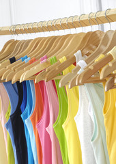 colorful clothing hanging on wooden hangers